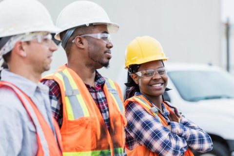 Three construction workers in hardhats and safety vests